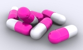 Nærbillede af syv lyserøde piller isoleret på den hvide baggrund