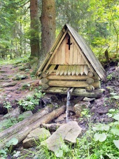 Cabană din lemn cu jet natural de apă în pădure